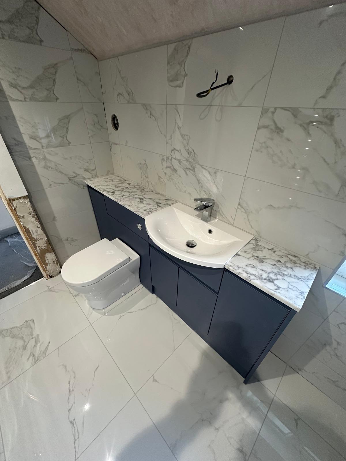 Completed bathroom plumbing work with basin, taps and waste connected